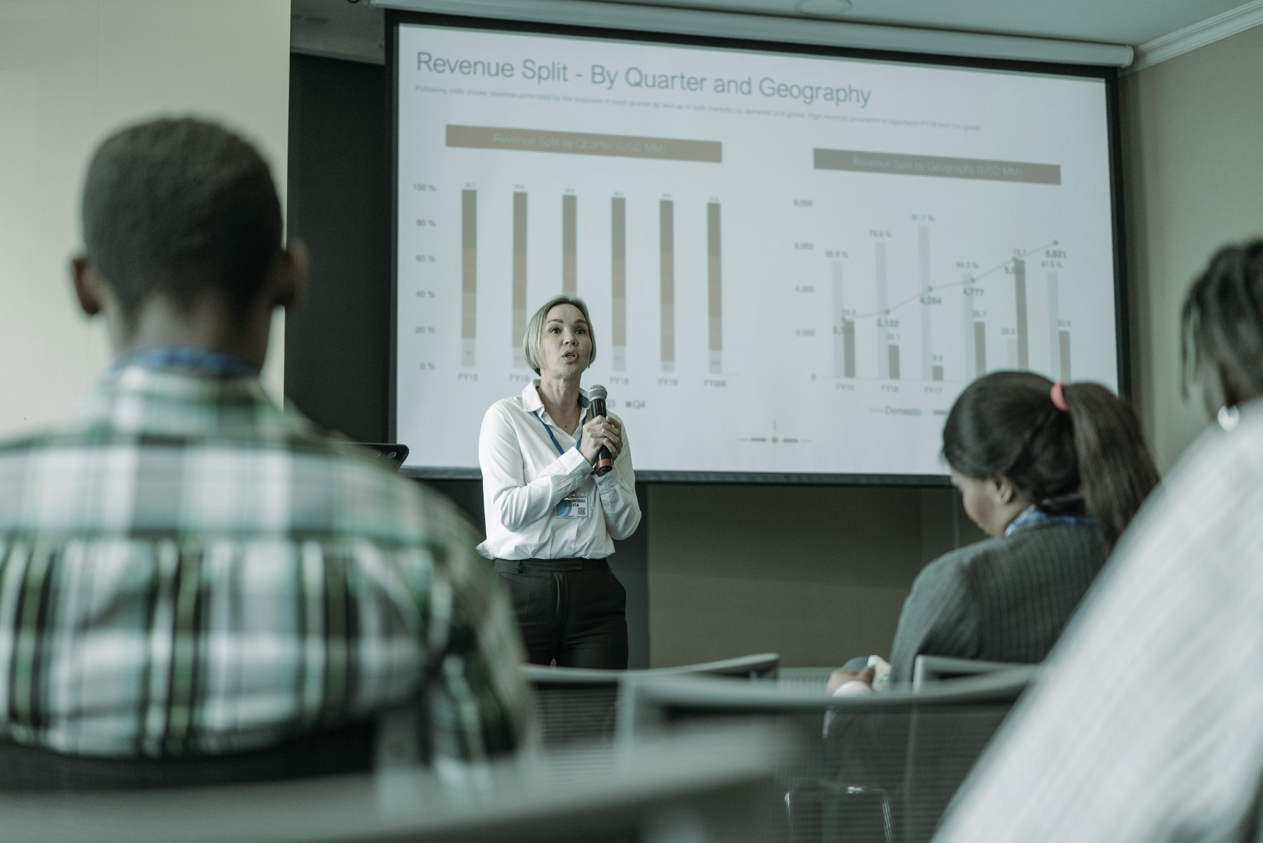 Presenter speaking to colleagues in a meeting room, seen from the audience