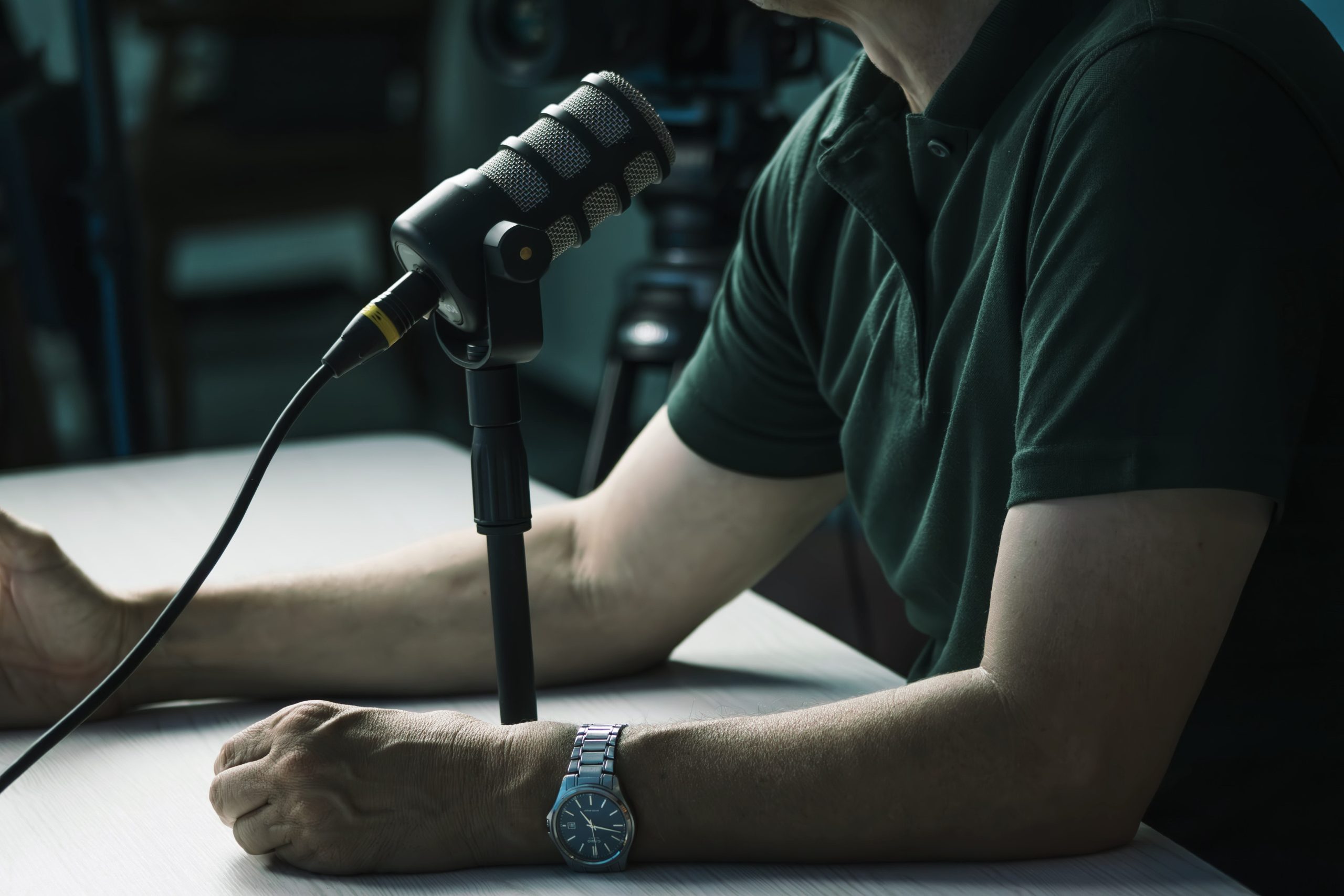 Man speaking into a podcast microphone during a recording